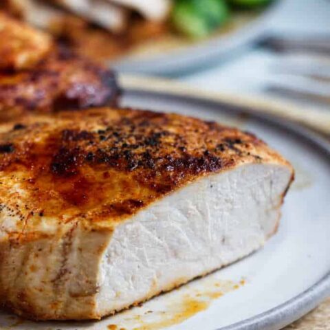 A chipotle air fryer pork chop sliced open to see the white meat.