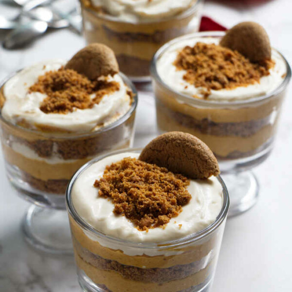 4 layered desserts of no bake cheesecake in parfait glasses