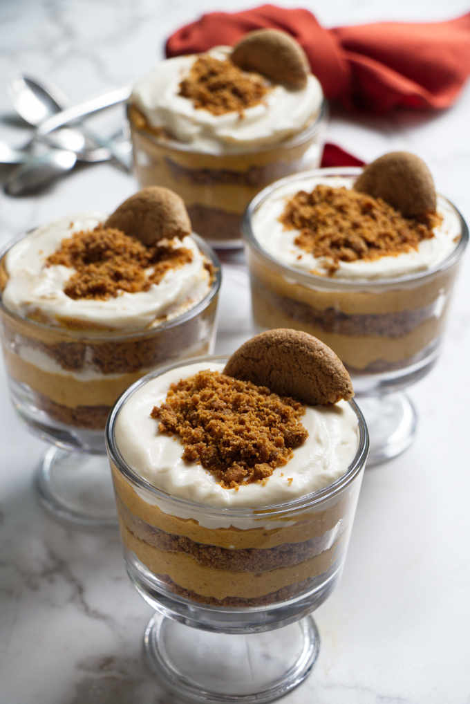 4 layered desserts of no bake cheesecake in parfait glasses