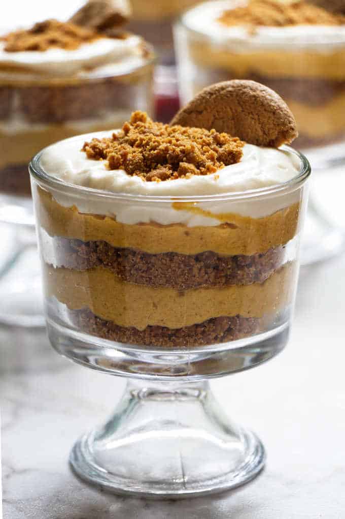 A dish of no bake cheesecake parfait with a gingersnap cookie on top