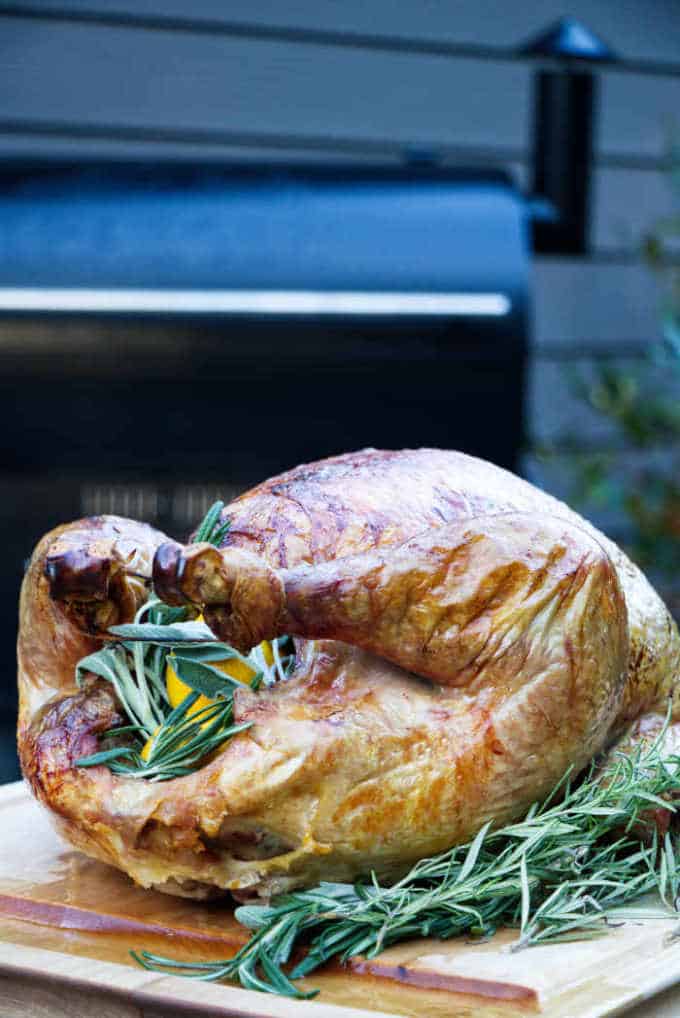 A perfectly juicy and flavorful turkey stuffed with herbs and citrus and resting on a cutting board.