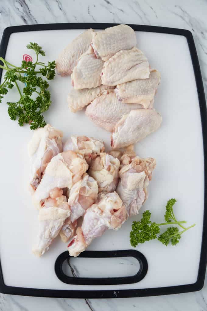 drumettes and wingettes on a white cutting board with parsley garnish