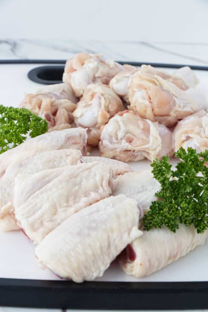 drumettes and wingettes on a white cutting board with parsley garnish