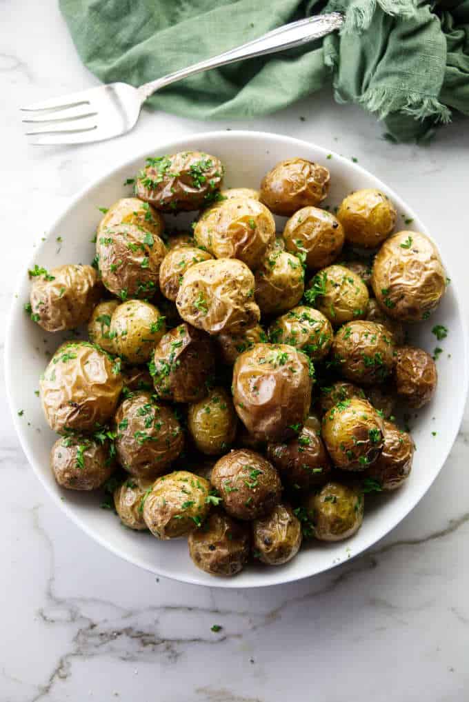 A serving dish of baby parsley potatoes.