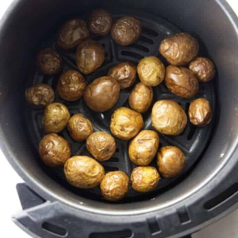 Baby potatoes in an air fryer basket.