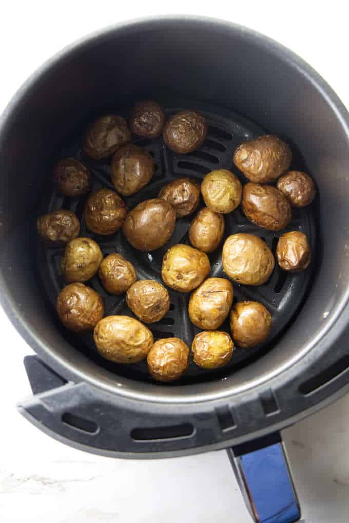 Baby potatoes in an air fryer basket.