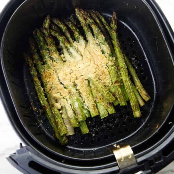 Asparagus in an air fryer basket.