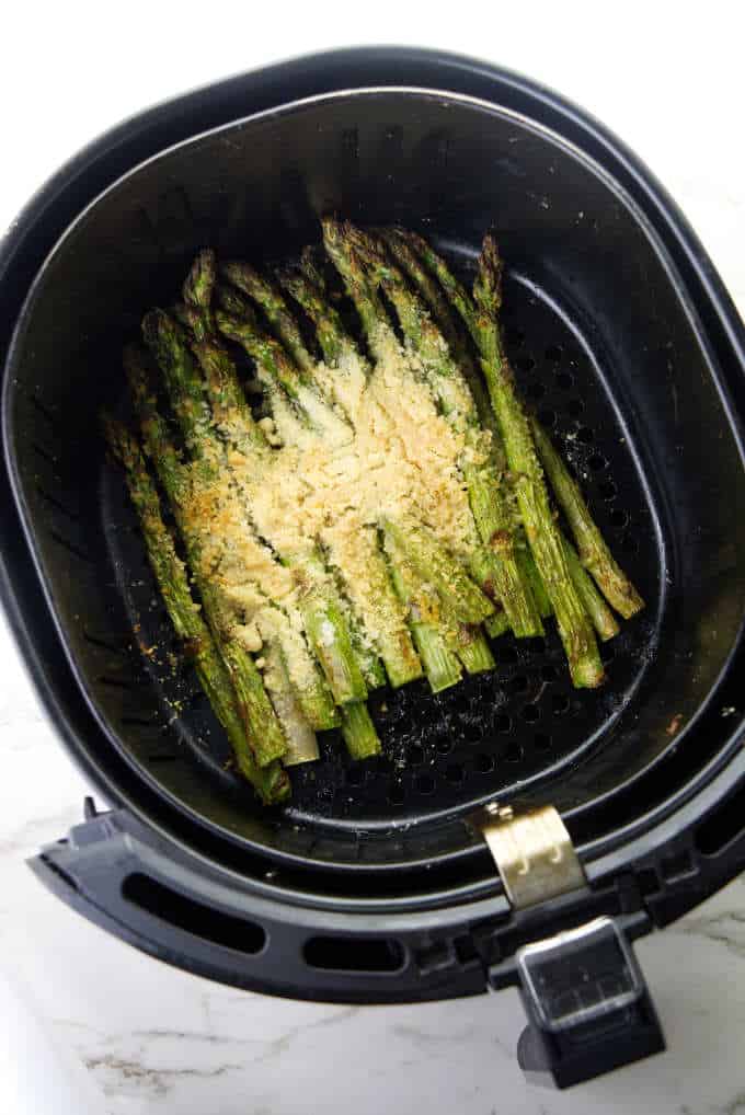 Asparagus in an air fryer basket.