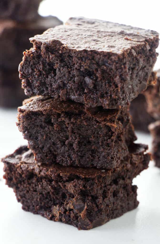 Three slices of moist brownies stacked on each other.