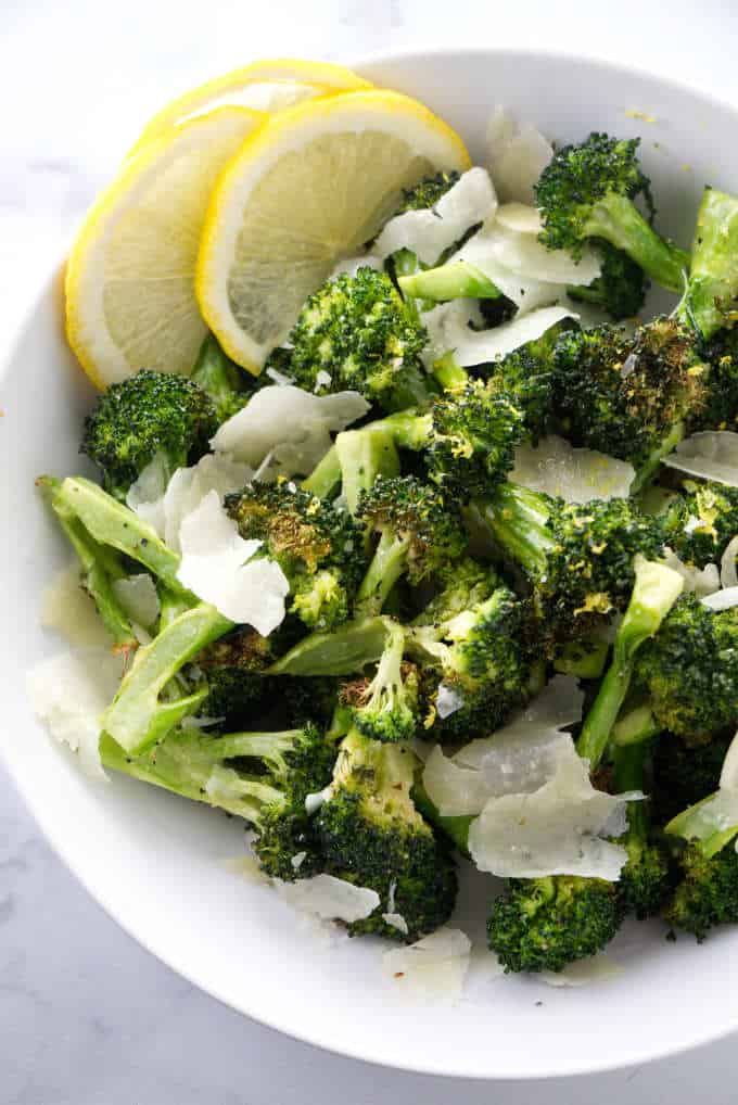 Broccoli in a bowl with parmesan and lemon.
