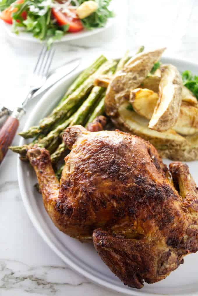 A cornish game hen on a dinner plate.