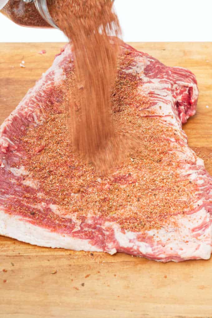 Putting dry rub on brisket