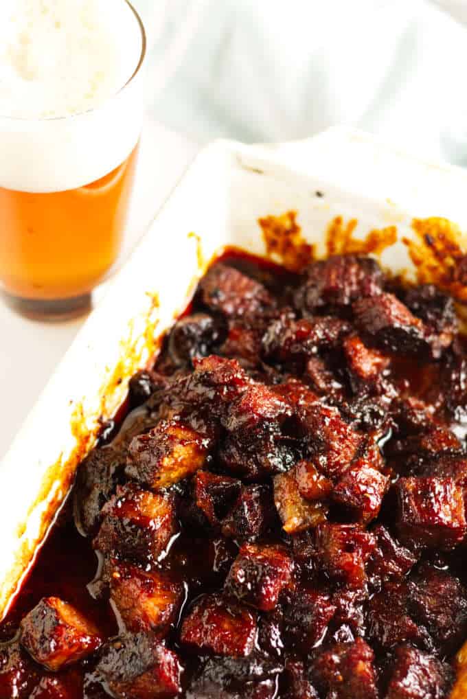 Smoked brisket burnt ends in a white dish covered in BBQ sauce.