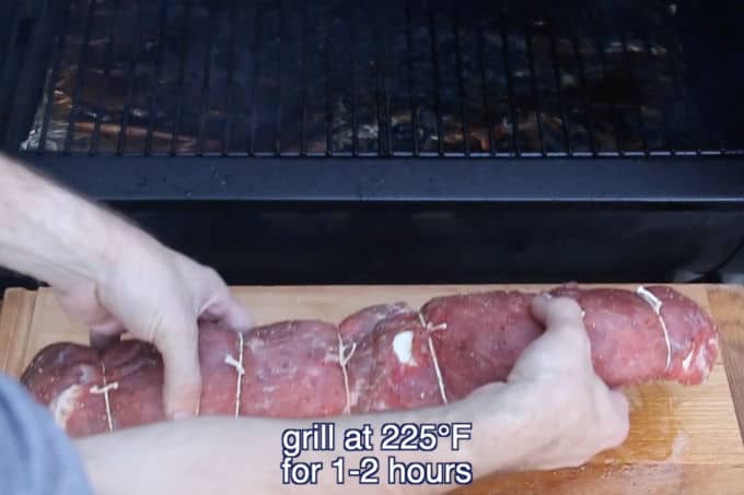 placing shrimp stuffed flank steak on grill