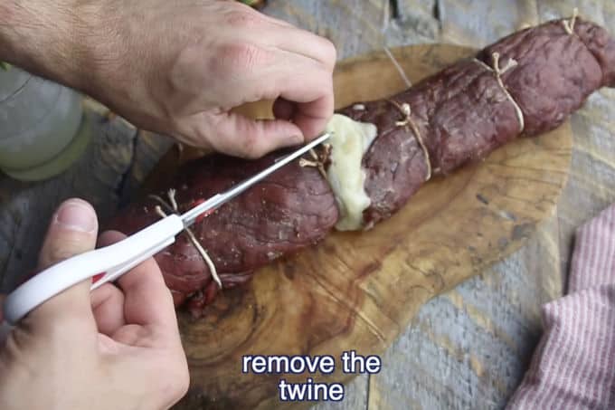 cutting twine off from shrimp stuffed flank steak
