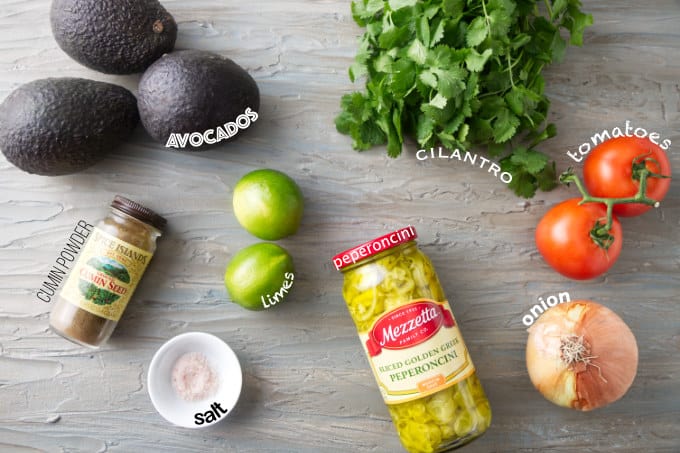 Ingredients used to make guacamole with tomatoes and pepperoncini.