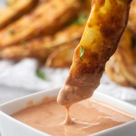 Dipping a jo jo potato wedge into some fry sauce.