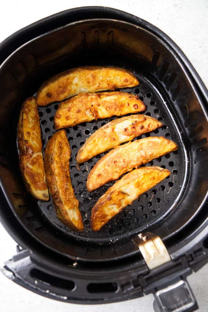 Seven potato wedges in the air fryer that look just like jo jo potatoes.