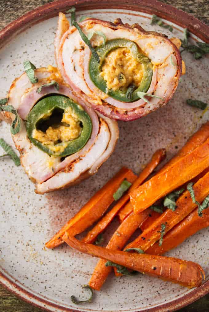 Jalapeño popper stuffed chicken breast sliced and plated with some air fryer carrots.