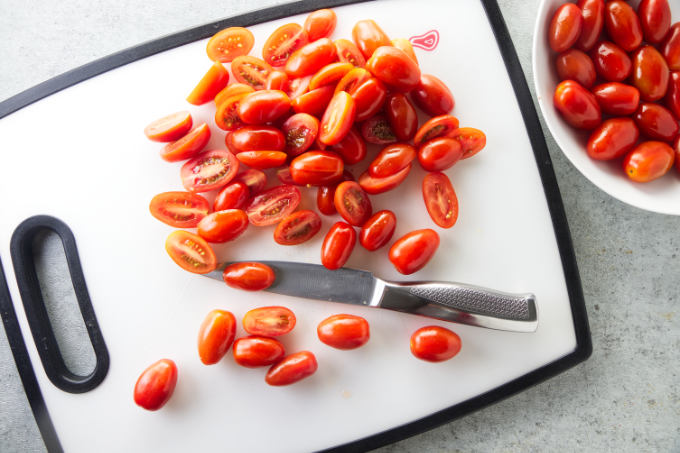 Slicing cherry tomatoes in half.