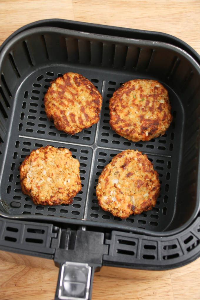 salmon cakes cooked to golden brown in air fryer basket