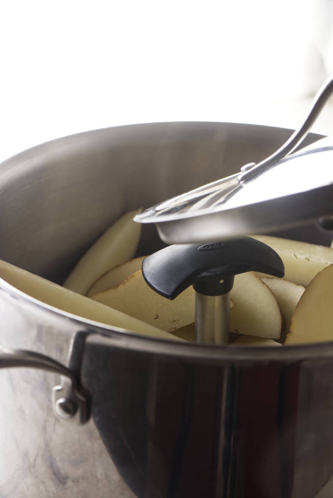 Precooking potato wedges in a large pot.
