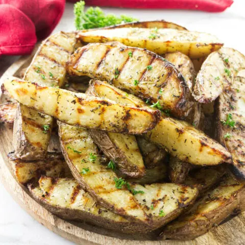 A serving platter with grilled potatoes.