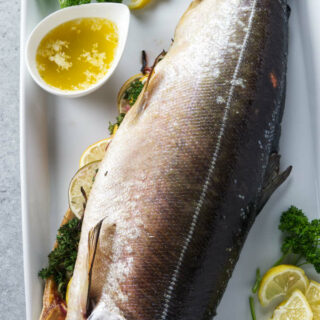 Whole salmon stuffed with citrus and aromatics on serving platter