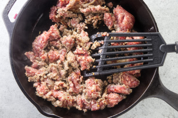 Cooking the sausage in a skillet.