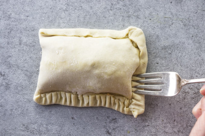Crimping the edges of a breakfast pocket with a fork.