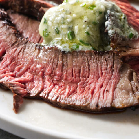 Slices of grilled chuck roast with blue cheese butter.