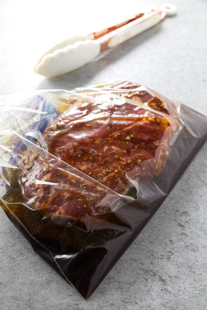 A steak and marinade in a zipper sealed bag.