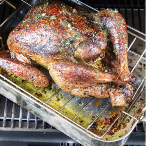 A turkey in a Traeger grill with herbed dry brine.