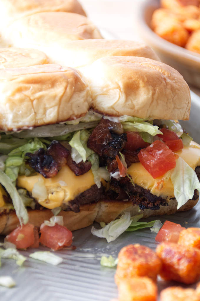 smashburger sliders assembled on a sheet pan with tater tots.