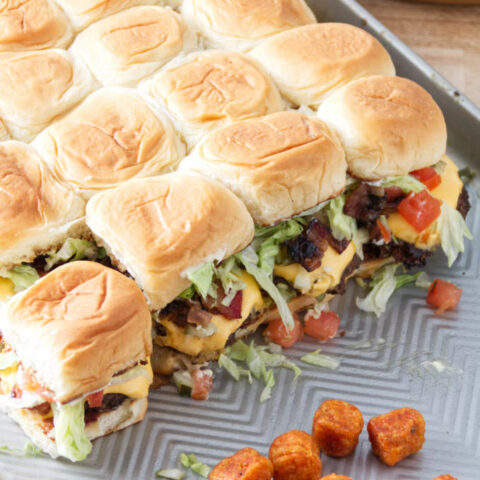 smashburger sliders assembled on a sheet pan with tater tots.