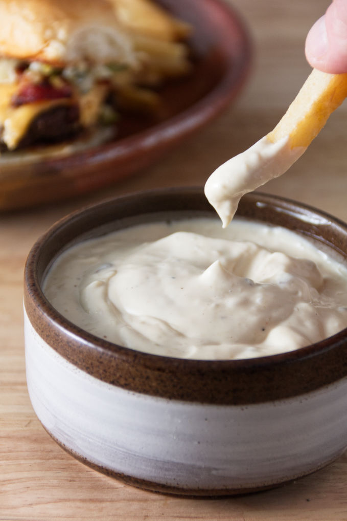 donkey sauce in a ceramic bowl with a french fry dipping in