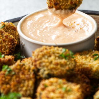 Dipping a fried pickle in sauce.