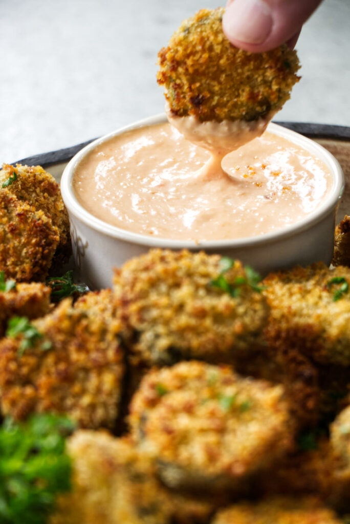 Dipping a fried pickle in sauce.