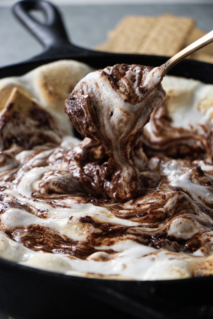 Stirring chocolate and marshmallows together.