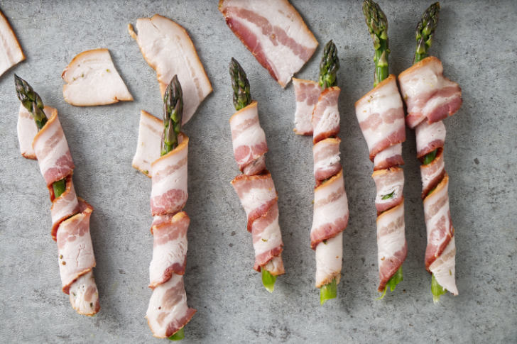 Wrapping asparagus spears in bacon.