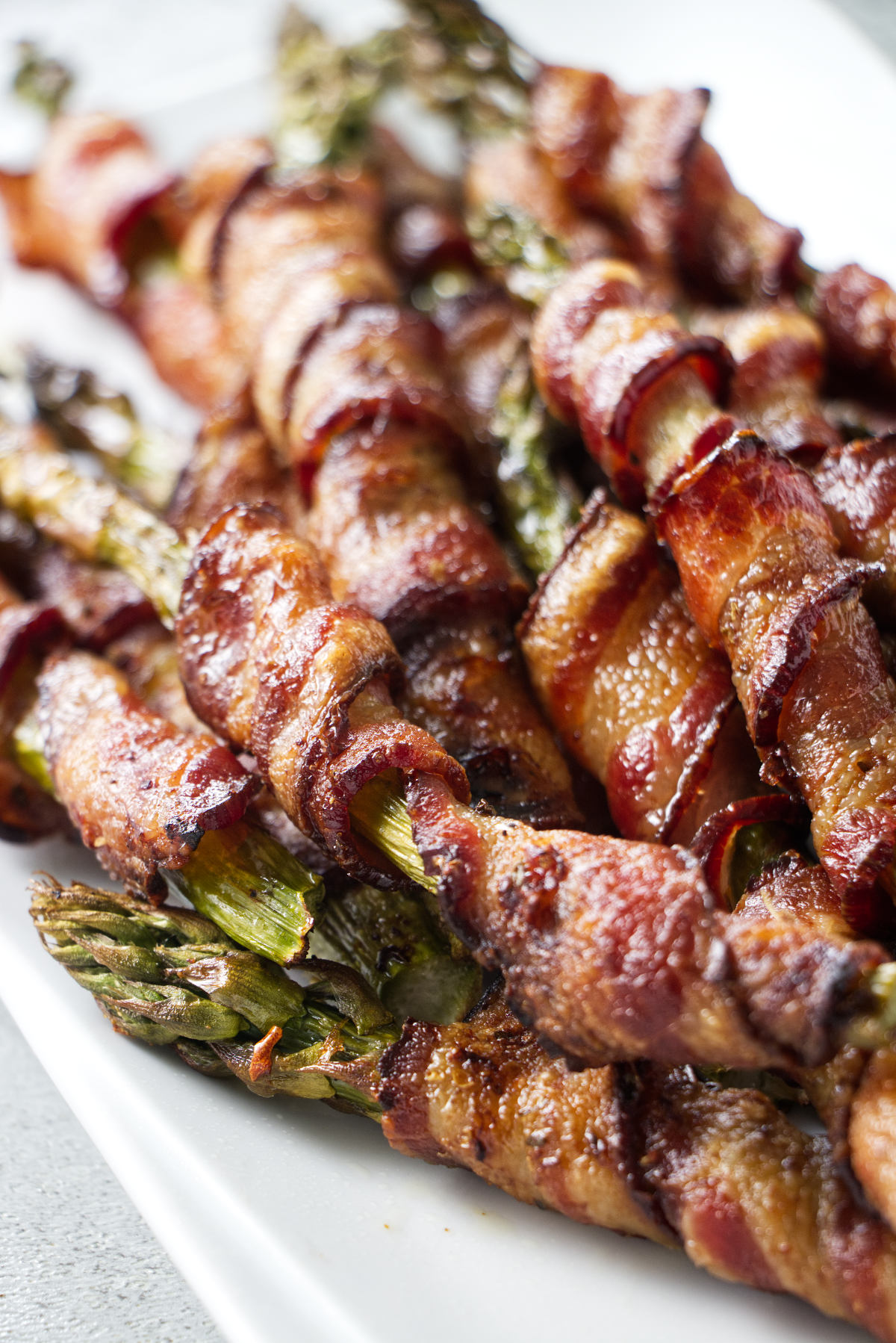 A plate of asparagus wrapped in bacon.