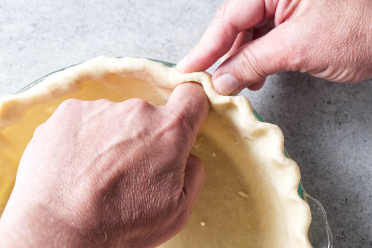 Pinching the edges of a pie crust.