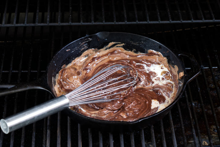 Stirring cream into melted chocolate.