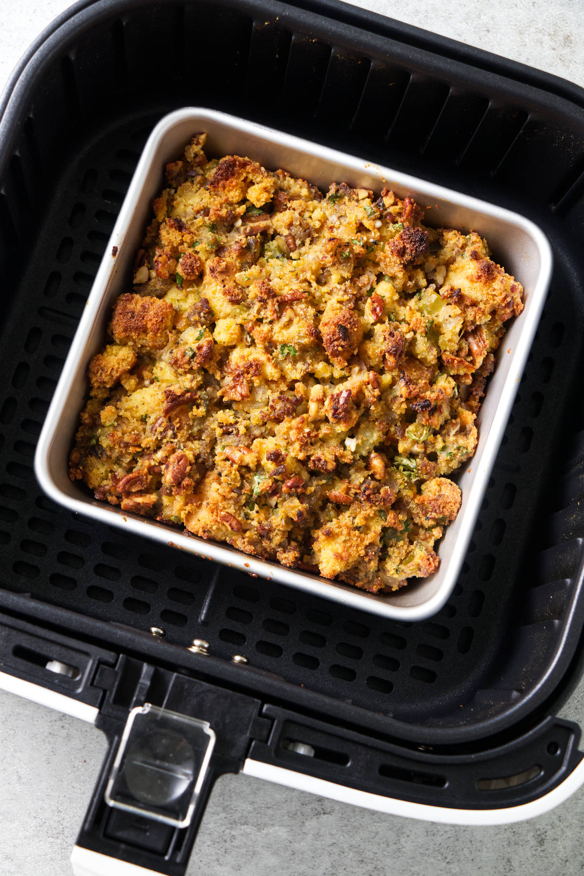 Bread stuffing in an air fryer basket.