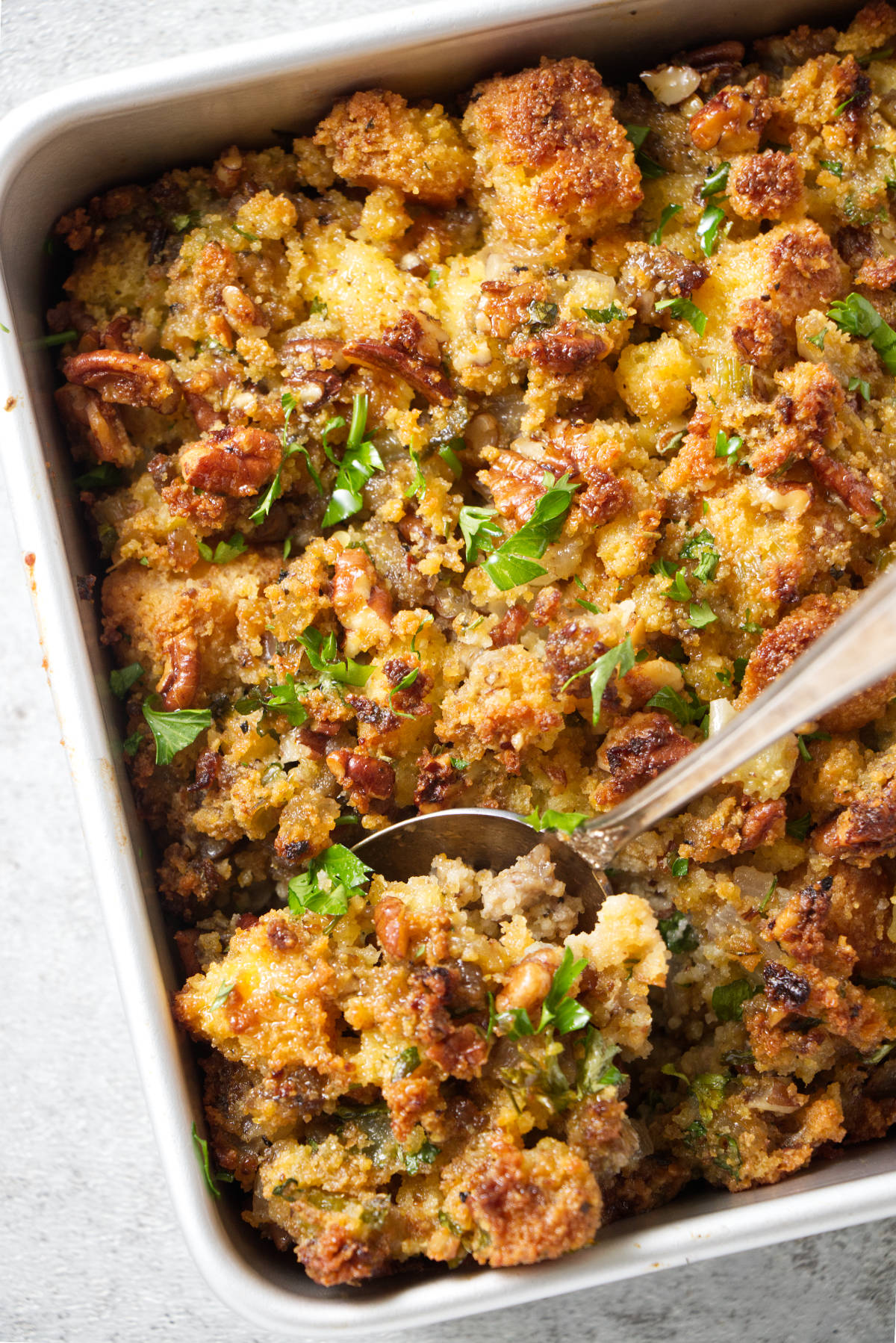 Scooping stuffing out of a pan.