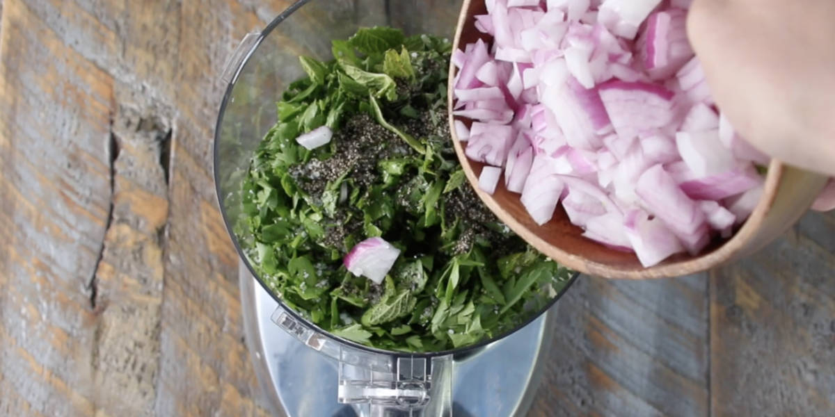 chimichurri ingredients going into food processor before pulsing