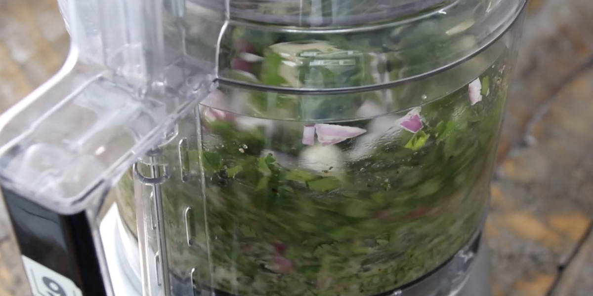 chimichurri being pulsed and blended in food processor