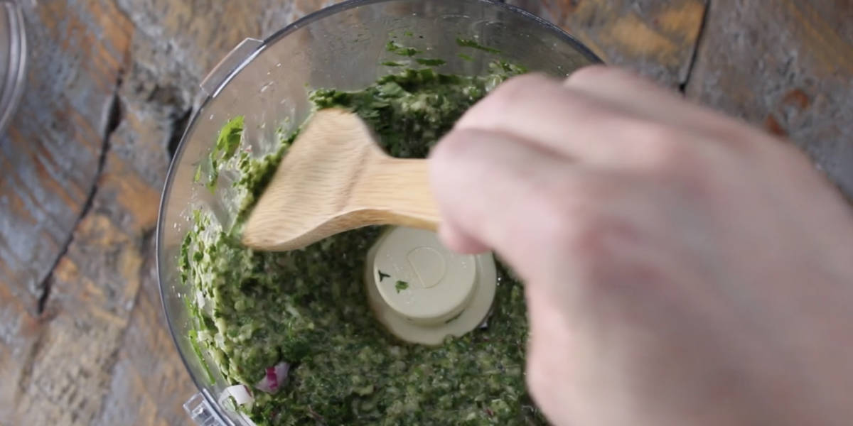 scraping edges of food processor after pulsing chimichurri