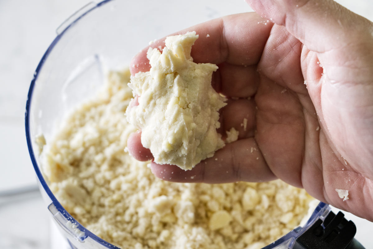 Squeezing pie dough together to see if it is ready to roll.