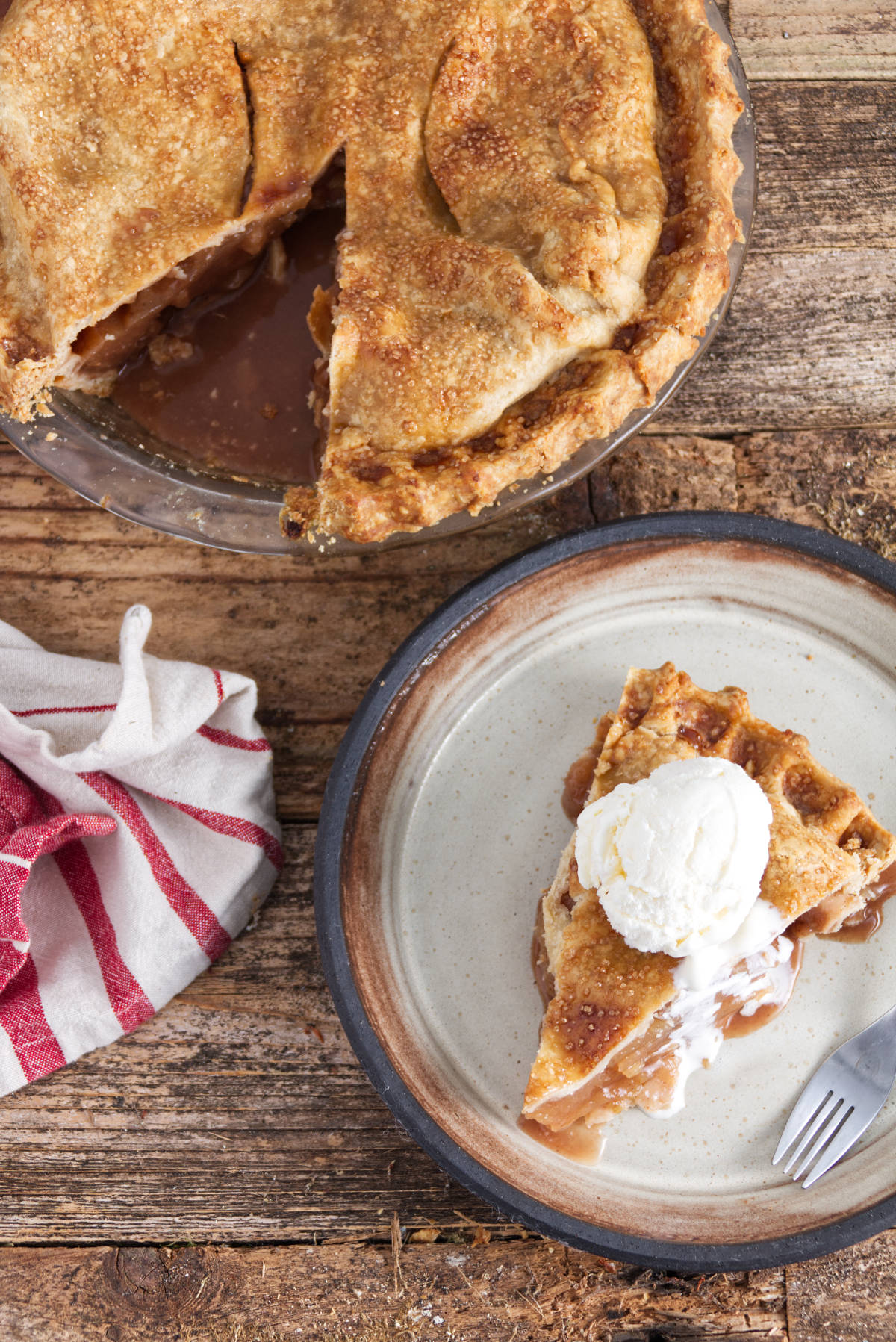 slice of traeger smoked apple pie with a scoop of vanilla ice cream on top and rest of pie above it